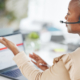 Side view of woman talking to someone on headset while on laptop