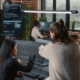 Two workers looking at code on computer monitor