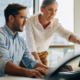 two workers look at computer